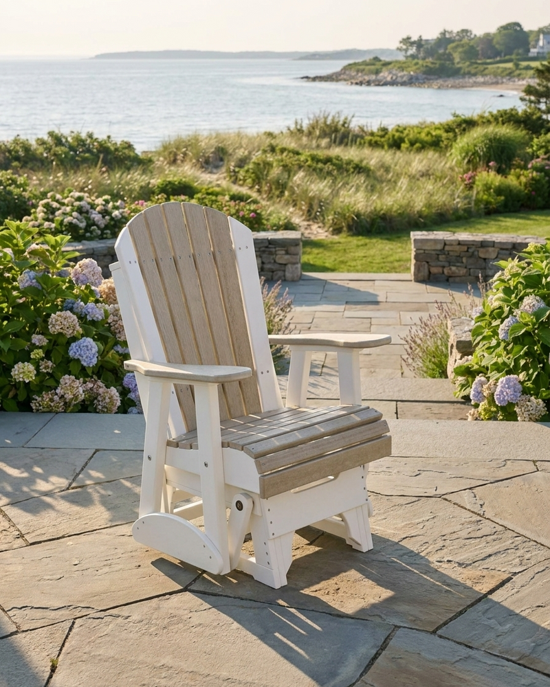 White Adirondack chair on a stone patio with a scenic view of water and greenery.