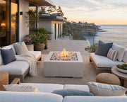 HPC 40-inch Alea natural concrete fire pit with ivory beach stones on an elevated patio with ocean views.  