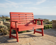 Red bench on a stone patio with a scenic background