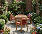 Anderson Teak Bhama 42 inch square dining table with four Junus dining chairs with henna cushions situated in a private city garden with flowers and shrubs.  
