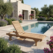 Anderson Teak Capri Sun Lounger with adjustable backrest positioned poolside on a stone patio, surrounded by lavender and flowering plants