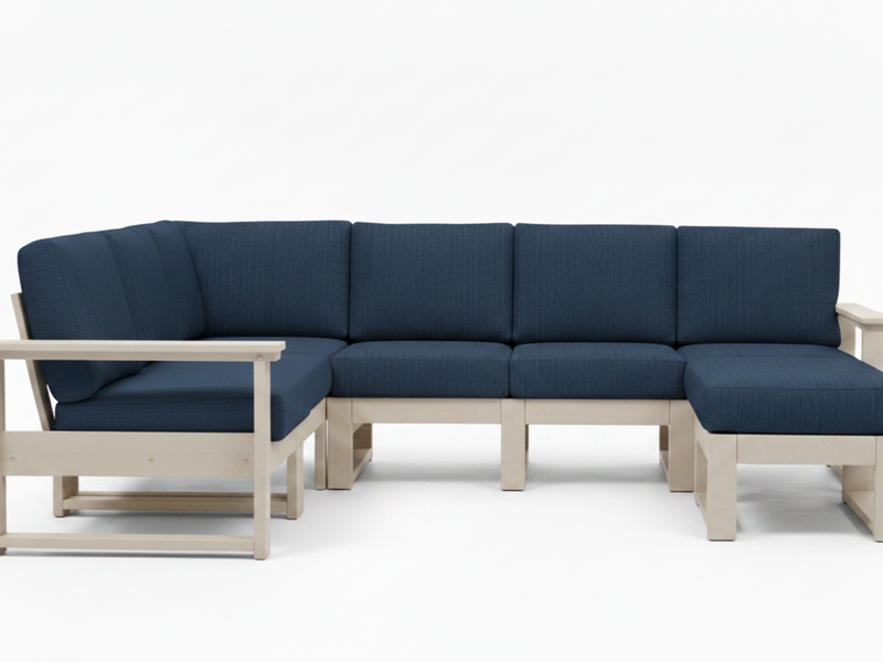 A modern outdoor sectional sofa with dark blue textured fabric cushions and a light natural wood frame, shown against a plain white studio background.