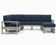 A modern outdoor sectional sofa with dark blue textured cushions and a light gray frame, shown against a plain white background.