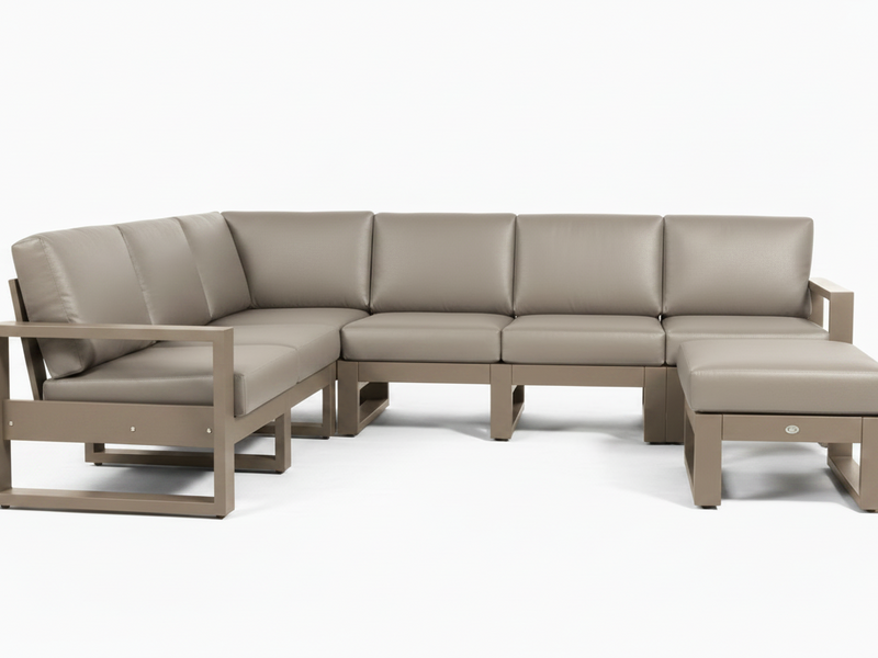 A modern outdoor sectional sofa set with a left-facing armchair, a curved three-seat section, a right-facing chaise ottoman, and a matching side table, all in a taupe-beige leather-like material with a weathered taupe frame, shown on a white background.