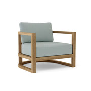 Junus teak armchair with cast mist cushion on a white background. 
