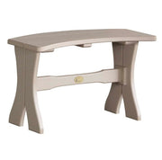 A curved outdoor bench with a light beige finish, featuring a thick horizontal support beam with a small gold brand plaque in the center.