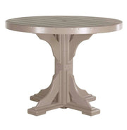 A round outdoor dining table with a slatted top and a sturdy pedestal base, finished in a warm taupe-beige color, shown against a plain white background.