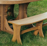 A close-up outdoor shot of a rustic  picnic table and matching bench set on green grass.