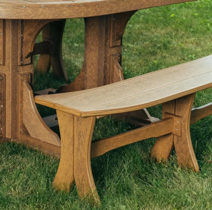 A close-up outdoor shot of a rustic  picnic table and matching bench set on green grass.