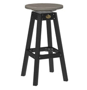 A swivel bar stool with a round gray seat and a black four-legged frame, featuring a small oval metal emblem on the upper crossbar.
