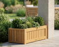 Teak straight wooden planter with lush greens and plants on a stone patio next to a stone column. 