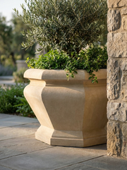 Octagonal limestone planter on a stone patio next to a stone column.  