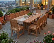 Anderson Teak Shara Rialto 13-Piece Rectangular Dining Set on a stone patio with city views.  