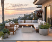 Alea 40-inch clay concrete fire pit on a stone patio centered amongst a teak seating area with views of the ocean.  