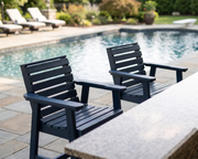 2 federal blue bar height chairs in front of a bar near a pool