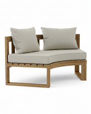 Circular teak bench with cast silver cushions on a white background.  