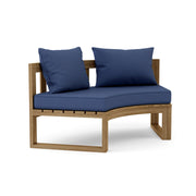 Circular teak bench with navy cushions on a white background.  