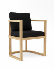 Anderson teak junus dining armchair with black cushions on white background.  
