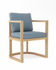 Anderson teak junus dining armchair with cast ocean cushions on white background.  