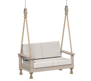 Beige swing with white cushions hanging on a white background