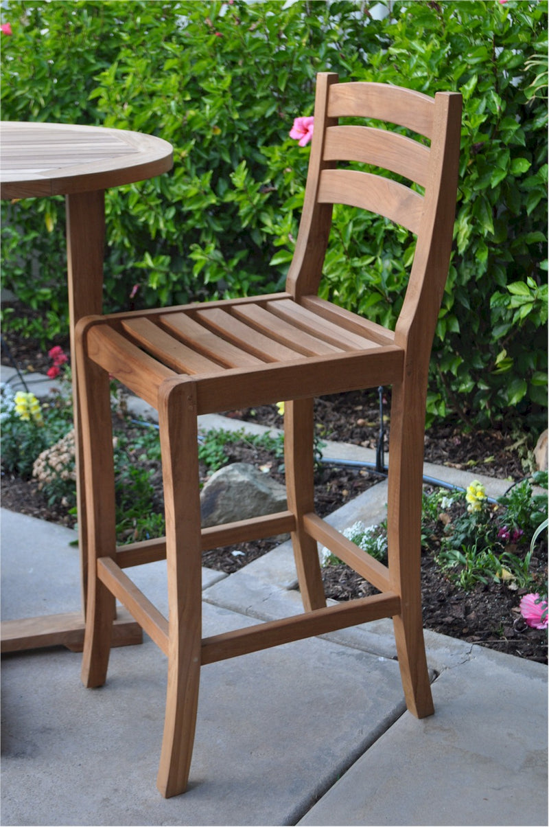 Wooden bar stool on a patio with a garden background