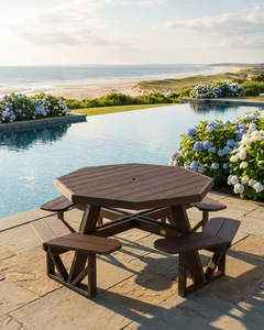 Octagonal picnic table with benches by a poolside with flowers and ocean view