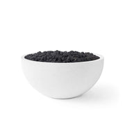 Serenade lightweight natural concrete fire pit with black lava rocks on a white background.  
