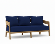 Toscana teak sofa with true blue cushions on a white background.