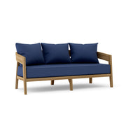Toscana teak sofa with navy cushions on a white background.